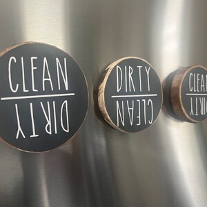 May include: Three round black wooden signs with white text. The signs say "Clean Dirty" and are flipped to show either "Clean" or "Dirty".
