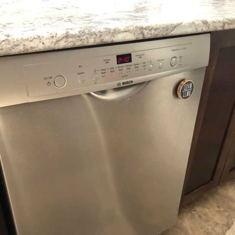 May include: A stainless steel dishwasher with a digital display showing "2:10". The dishwasher has a variety of buttons and controls, including "Sanitize", "Auto Wash", "Normal Wash", "Delicate Wash", "Express Wash", "Half Load", "Delay Start", and "On/Off". The dishwasher is made by Bosch.