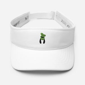 May include: White visor with a green and black embroidered design. The visor has a curved brim and an adjustable strap. The embroidered design is a cartoon character's hat and collar.