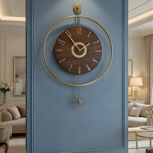 Puede incluir: Un reloj de pared moderno con una esfera marrón oscuro y manecillas y marco dorados. El reloj es circular, con números romanos y un péndulo. Cuelga de una pared azul, añadiendo un toque de elegancia a la habitación.