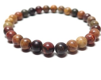 May include: A multi-colored stone bracelet with round beads in shades of brown, red, and beige.