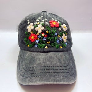 May include: A black denim baseball cap with embroidered flowers in shades of red, white, yellow, blue, and green.