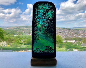 Vía Láctea y árboles pintados a mano sobre vidrio en soporte de madera