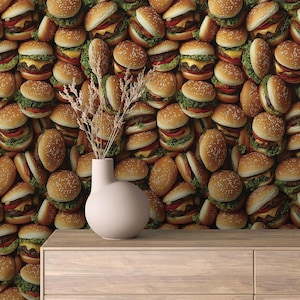 Könnte beinhalten: Eine Nahaufnahme einer Wand, die mit Mini-Cheeseburgern bedeckt ist. Die Burger sind in einem zufälligen Muster angeordnet und haben alle unterschiedliche Größen. Vor der Wand steht eine weiße Vase mit getrockneten Blumen.