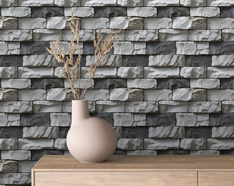 May include: A vase with dried flowers sits on a wooden shelf in front of a wall covered in a faux stone brick wallpaper. The wallpaper is a mix of gray and white bricks.