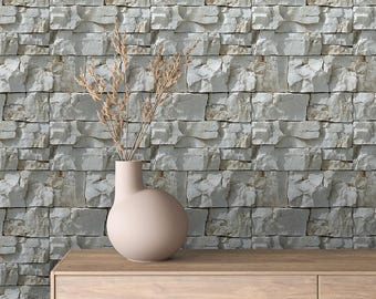 May include: A light brown wooden dresser with a light beige vase with dried flowers on top. The dresser is in front of a wall with a white stone tile pattern.