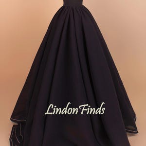 Peut inclure: Une jupe ample bleu marine foncé à taille haute, présentée sur un mannequin. La jupe a un design fluide et volumineux, avec un ourlet cousu blanc. Le texte "Lindon Finds" est visible sur la jupe.