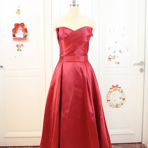 May include: A strapless, red satin gown with a sweetheart neckline and a flowing skirt.