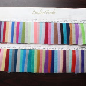 May include: A color chart with 74 fabric swatches. The swatches are arranged in two rows of 37. The swatches are all different colors, including red, blue, green, yellow, pink, purple, orange, brown, black, white, and gray.
