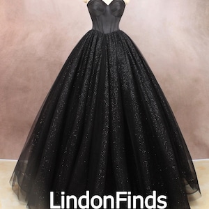 May include: A black strapless ball gown with a fitted bodice and a full skirt made of tulle with glitter. The gown is on a mannequin and the skirt is flowing out around it. The text "LindonFinds" is visible at the bottom of the image.