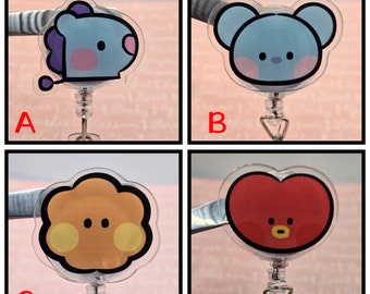 May include: Four different character designs on clear plastic retractable badge holders. The designs are a purple and blue character with pink cheeks, a blue character with pink cheeks, a yellow character with orange cheeks, and a red heart character with a yellow mouth.