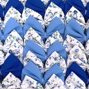 Puede incluir: Una colección de lazos de tela azul y blanco con un patrón floral. Los lazos están dispuestos en filas, con los lazos azules en la parte superior y los lazos blancos en la parte inferior.