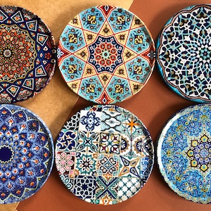 Puede incluir: Seis platos de cerámica decorativos con intrincados patrones geométricos en tonos de azul, amarillo, rojo y blanco. Los platos presentan una variedad de diseños, incluyendo estrellas, flores y formas geométricas.