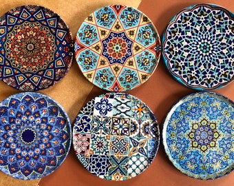 May include: Six decorative ceramic plates with intricate geometric patterns in shades of blue, yellow, red, and white. The plates feature a variety of designs, including stars, flowers, and geometric shapes.