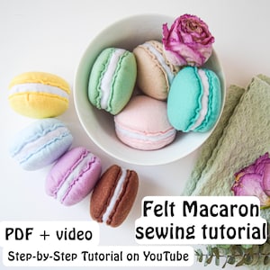 Könnte beinhalten: Eine Auswahl an Filz-Macarons in Pastellfarben wie Gelb, Blau, Rosa, Grün und Braun, angeordnet in einer weißen Schüssel und verstreut. Das Bild enthält den Text "Felt Macaron sewing tutorial" und "PDF + video Step-by-Step Tutorial on YouTube."