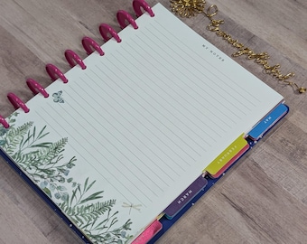 May include: A spiral-bound planner with lined pages and pink plastic rings. The planner features botanical illustrations and month tabs. The words "My Notes" are printed at the top of the page. A gold-colored bookmark is also present.