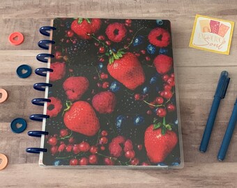 Op de afbeelding: Een blauwe en witte planner met een transparante hoes met een close-up afbeelding van een verscheidenheid aan rode bessen, waaronder aardbeien, frambozen en blauwe bessen.