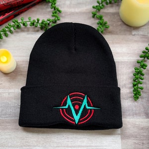 A black beanie embroidered with the Voxtek logo from Hazbin Hotel