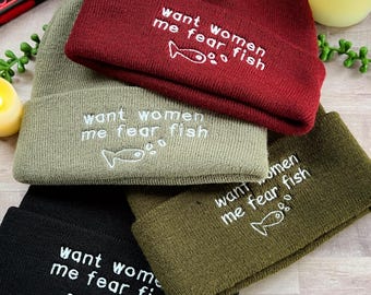 Peut inclure: Quatre bonnets en différentes couleurs, noir, vert, vert olive et bordeaux, avec le même texte brodé en blanc : "want women me fear fish" et un petit graphique de poisson.