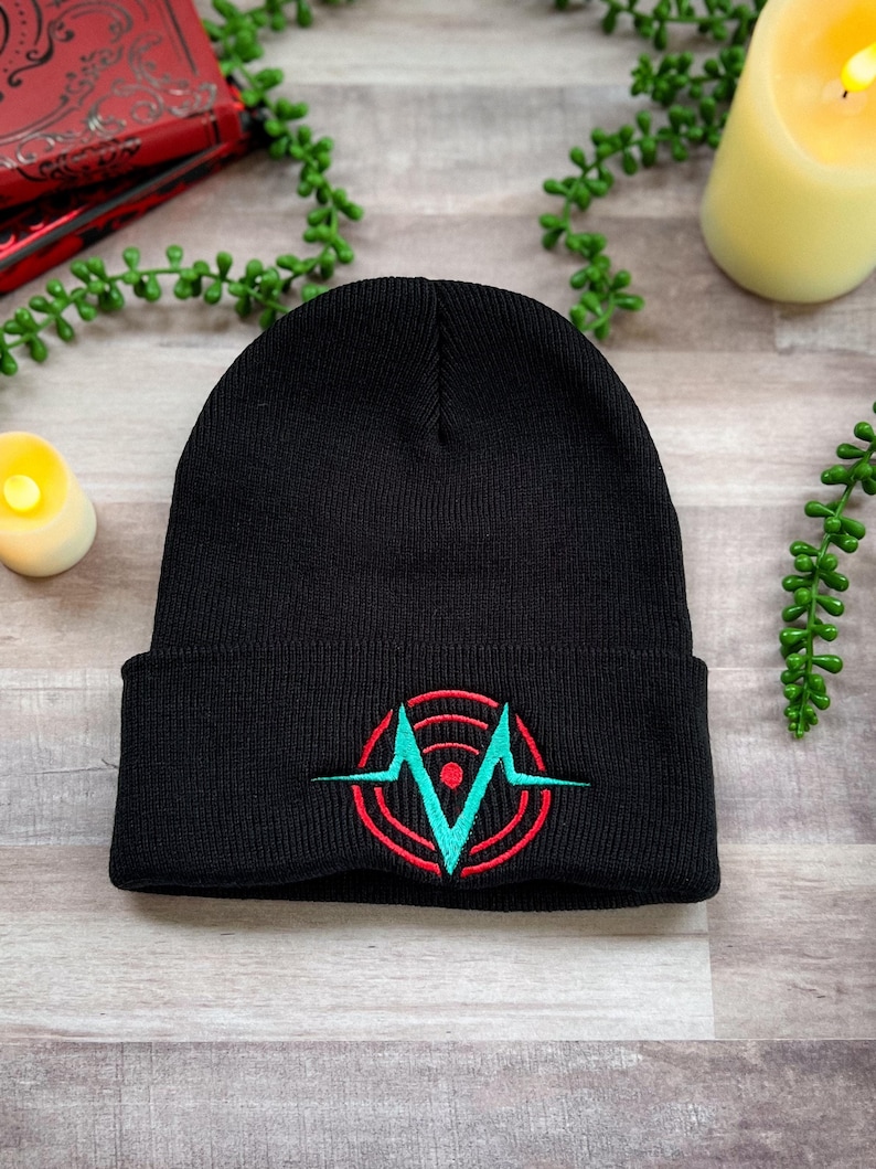 A black beanie embroidered with the Voxtek logo from Hazbin Hotel