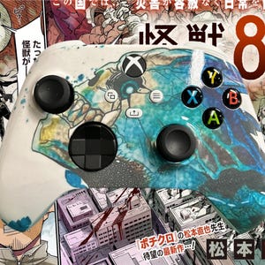 May include: A white Xbox controller with a blue and green abstract design. The controller has black buttons and a black D-pad. The text "怀畔 8号" is visible in the background.