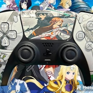 Puede incluir: Un mando PlayStation 5 DualSense blanco y negro con una piel personalizada que presenta personajes de anime de Sword Art Online. La piel presenta una variedad de personajes, incluidos Kirito, Asuna y Leafa. El mando tiene un diseño blanco y negro con un logotipo de PlayStation plateado.