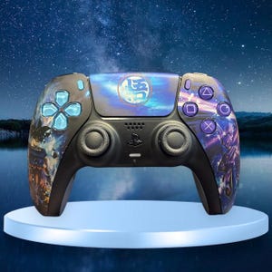 May include: A black PlayStation 5 DualSense controller with a custom design featuring a blue and purple galaxy pattern and a blue circle with Japanese characters in the center. The controller has a black and blue button layout.