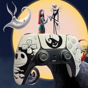 Może przedstawiać: Biało-czarny kontroler PlayStation 5 z Jackiem Skellingtonem i innymi postaciami z Miasteczka Halloween. Kontroler ma czarne joysticki i przyciski, z pełnią księżyca i ciemnoniebieskim tłem.