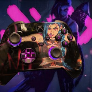 Könnte beinhalten: Ein schwarzer Xbox-Controller mit einer benutzerdefinierten Haut, die eine farbenfrohe Illustration einer weiblichen Figur mit blauen Haaren zeigt. Der Controller hat einen violetten Schein um die Knöpfe und die Augen der Figur.