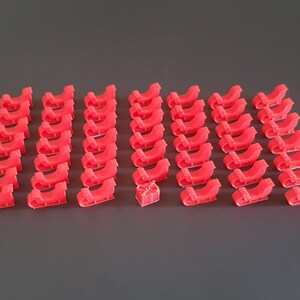 May include: A set of 36 red plastic miniature sleighs with a single red plastic miniature gift box in the center.