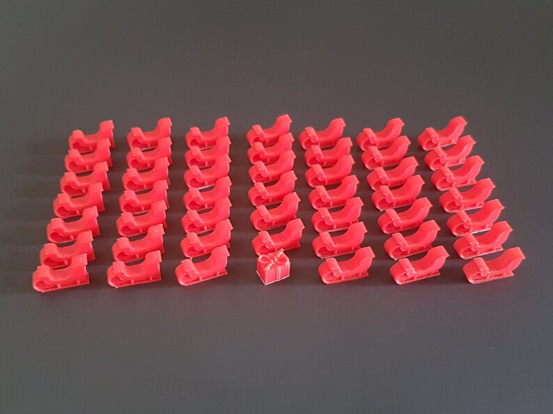 May include: A set of 36 red plastic miniature sleighs with a single red plastic miniature gift box in the center.