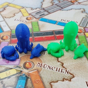 May include: A set of blue and green octopus and dolphin game pieces. The pieces are made of plastic and are designed to be used with a board game.