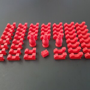 May include: A set of 3D printed red plastic Christmas sleighs and two snowman figurines. The sleighs are small and perfect for a miniature Christmas village or holiday scene.