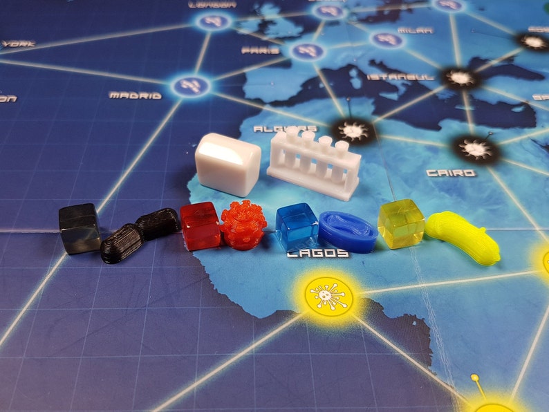 May include: A collection of colourful game pieces for a board game. The pieces include a white cube, a white test tube rack, a black cube, a black cylinder, a red cube, a red virus, a blue cube, a blue oval, a yellow cube, and a yellow virus.