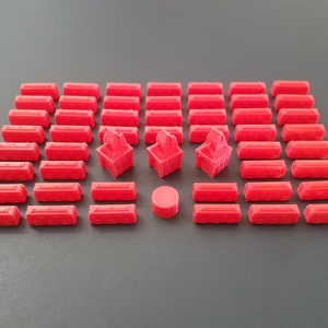 May include: A set of 40 red plastic game pieces, including 36 rectangular pieces and 4 larger, detailed pieces. The pieces are arranged in a rectangular pattern on a gray surface.
