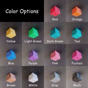 May include: Color options for a set of 12 small, cube-shaped blocks. The blocks are in the following colors: red, orange, yellow, light green, dark green, teal, blue, purple, pink, fuchsia, brown, white, gray, and black.