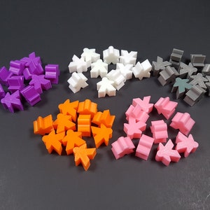 May include: A collection of 5 different colored plastic game pieces. The pieces are shaped like people and are in the colors purple, white, gray, orange, and pink.