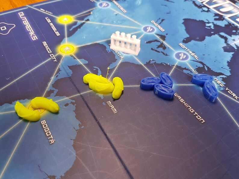 May include: A game board with a world map showing different cities. There are yellow and blue game pieces on the board. The game pieces are in the shape of small, curved cylinders. The game board also has a white plastic test tube rack.