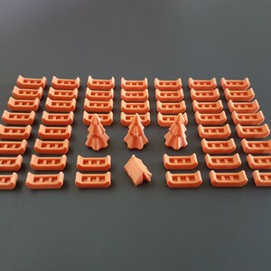 May include: A set of 40 orange canoe-shaped game pieces, 3 orange tree-shaped game pieces, and 1 orange tent-shaped game piece.