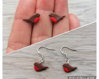 May include: A pair of dangle earrings featuring a brown and red robin bird charm. The earrings have silver hooks.