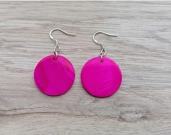 May include: A pair of pink oval earrings with silver hooks. The earrings are made of a shiny material that has a slight iridescent quality.