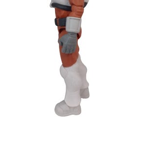 May include: A toy astronaut figure, featuring an orange and white spacesuit. The figure has gray gloves and a black belt. The white boots and knee pads are detailed with molded designs. The figure is set against a white background.