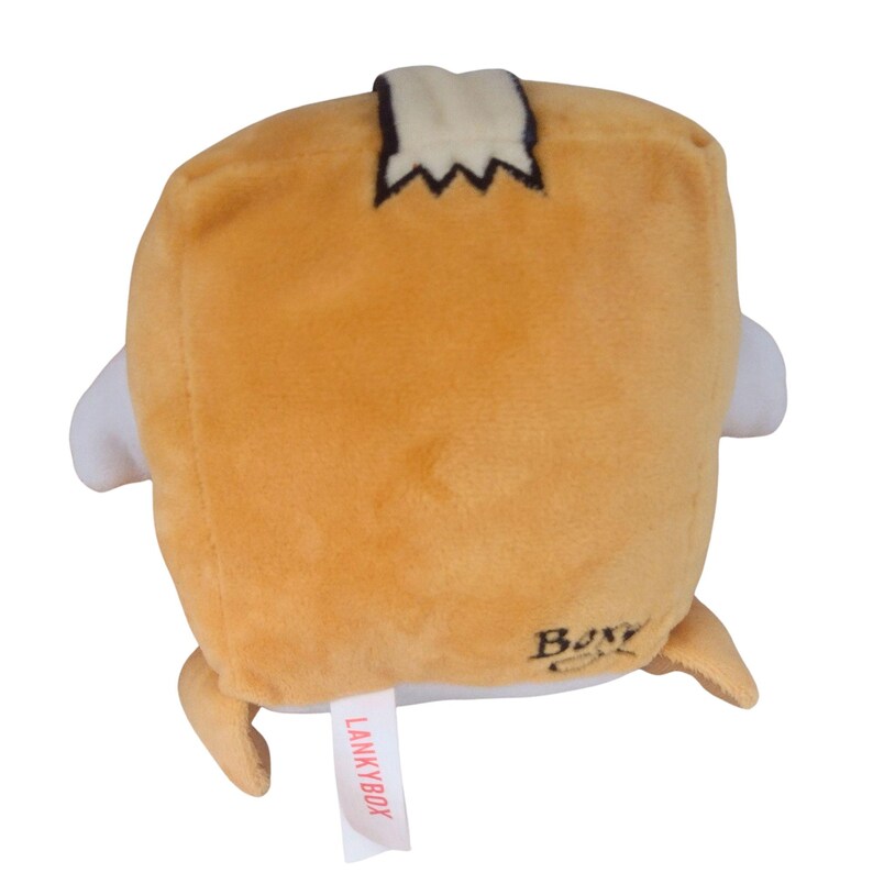 May include: A tan, cube-shaped plush toy resembling a cardboard box with white side appendages. It features a black stitched detail on top, the word Boxy embroidered in black on the lower right, and a white tag with the red text LANKYBOX.
