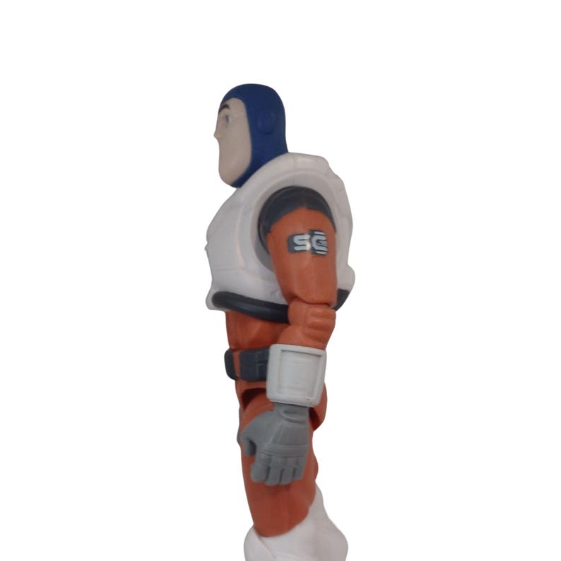 May include: A side view of a Buzz Lightyear action figure. The figure is wearing a blue helmet, white chest armor, and an orange and white spacesuit. The figure has gray gloves and a gray belt. The letters "SC" are printed on the right shoulder.