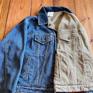 Op de afbeelding: Een blauw denim jack met een bruin corduroy paneel op de rug. Het jack heeft twee zakken aan de voorkant en &eacute;&eacute;n op de rug.