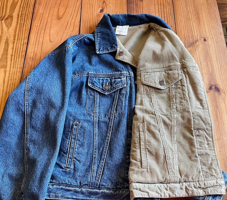 Op de afbeelding: Een blauw denim jack met een bruin corduroy paneel op de rug. Het jack heeft twee zakken aan de voorkant en &eacute;&eacute;n op de rug.