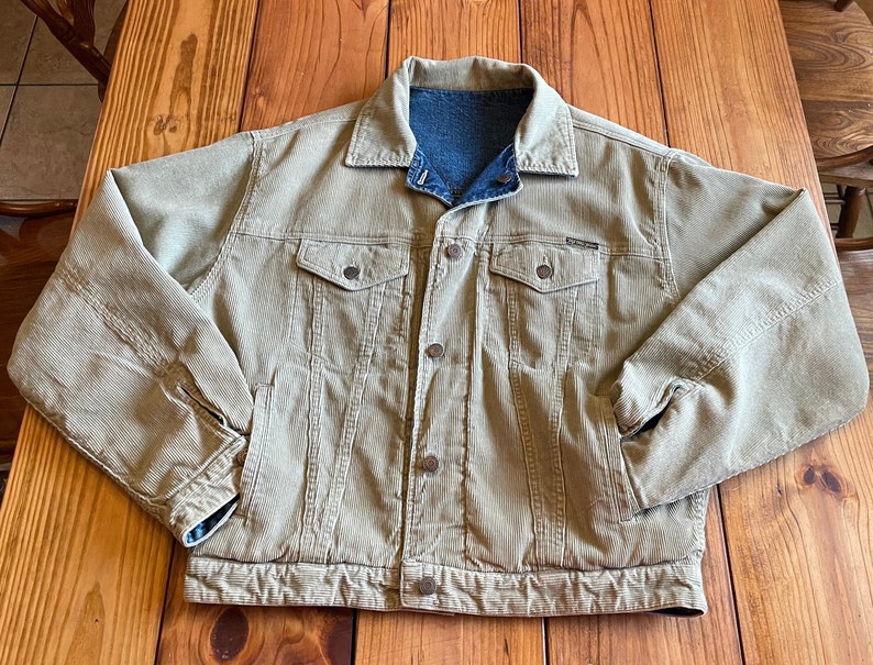 Op de afbeelding: Een beige corduroy jack met een denim voering. Het jack heeft een knoopsluiting, twee borstzakken en twee voorzakken.