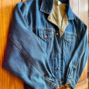 Op de afbeelding: Een blauwe denimjas met een corduroy voering. De jas heeft een knoopsluiting en twee voorzakken.