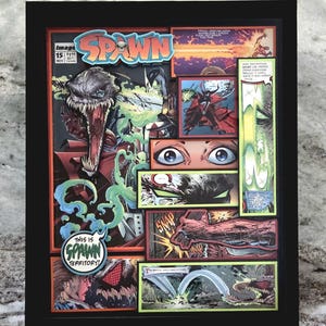 May include: Framed comic book art featuring the Spawn character. The artwork is a collage of panels from the comic, with vibrant colors and dynamic action scenes. The title "Spawn" is prominently displayed, along with the text "This is Spawn Territory!"