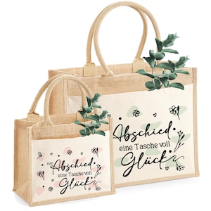 Pu&ograve; includere: Due borse tote in iuta beige con tasche bianche, con il testo tedesco "Abschied eine Tasche voll Gl&uuml;ck" in corsivo nero. Le borse hanno manici beige e sono decorate con rametti verdi e motivi floreali.